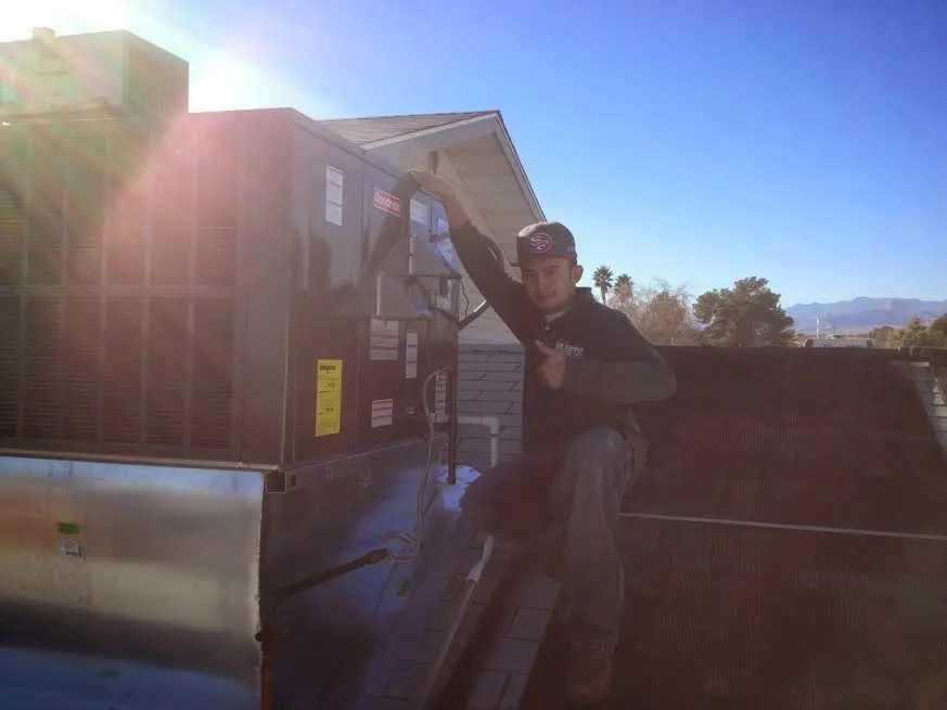 HVAC technician performing AC Tune-Up on a rooftop unit in Kaukauna